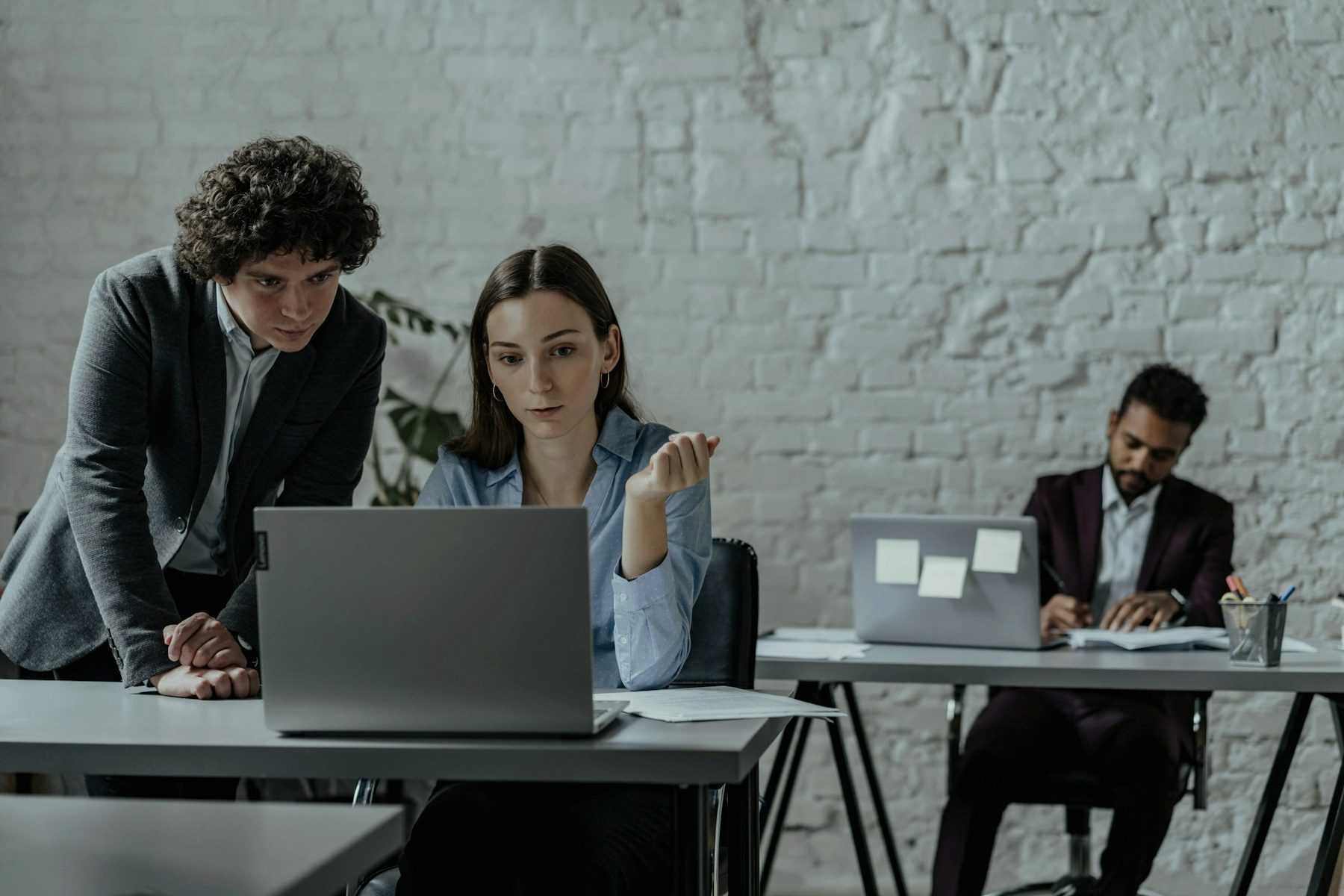 Two colleagues working together on a laptop in an office